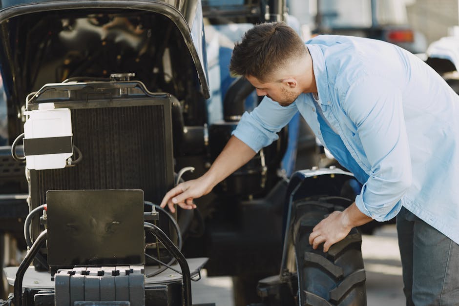 A mechanic in a blue shirt inspects a car engine outdoors, ensuring proper function.